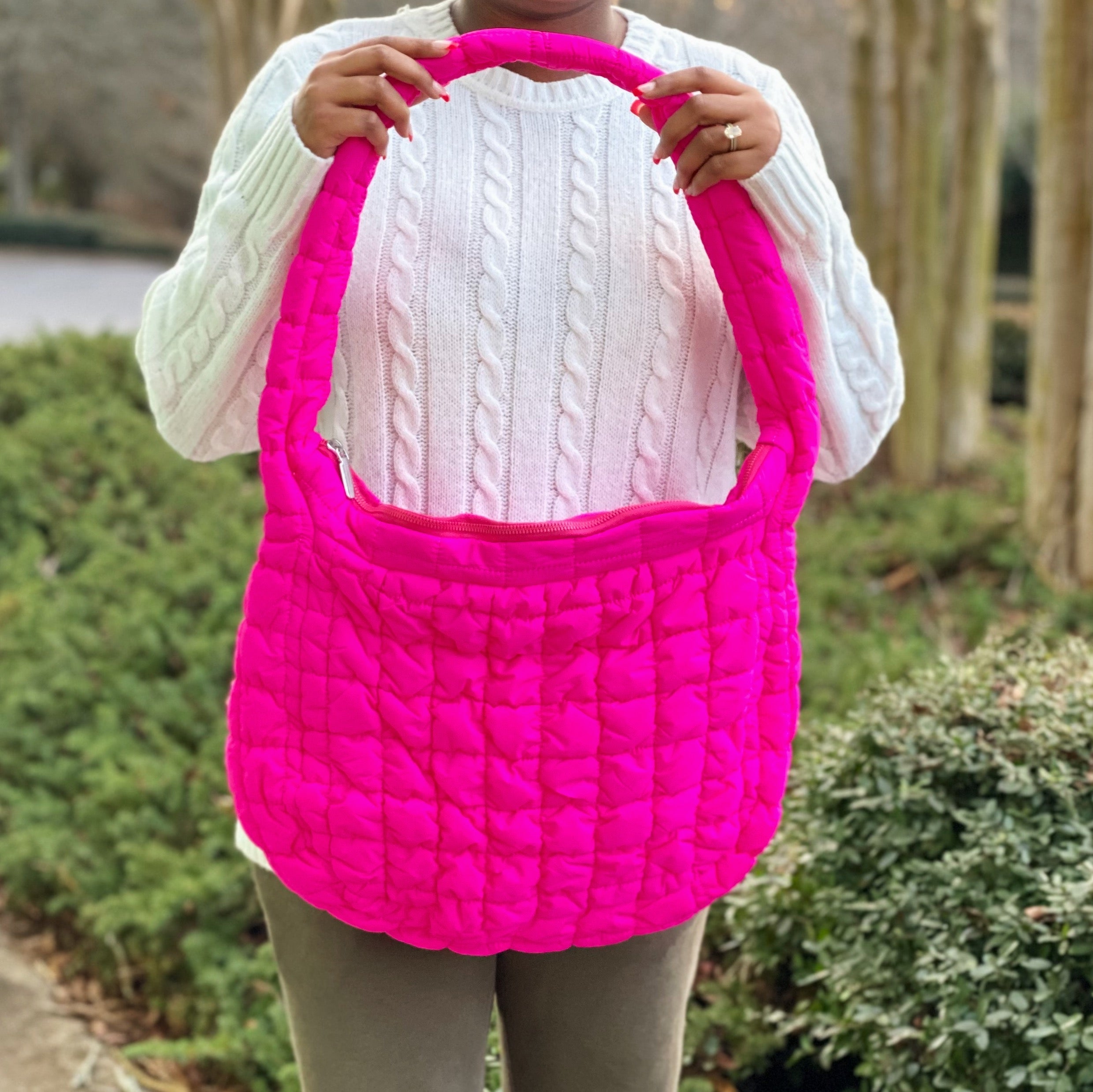 Woman holding a Carry All Quilted Cross Body Bag while wearing a cozy white sweater.